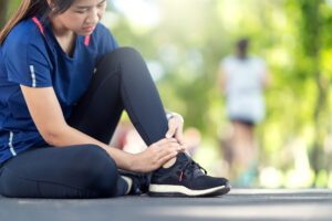 Young,Asian,Woman,Suffering,Ankle,Injury.,Runner,Girl,Is,Injured