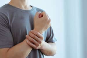 Man holding wrist and experiencing arthritis pain in Ogden, UT