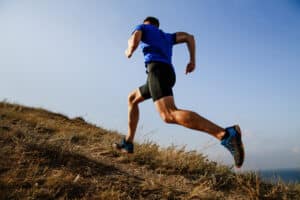 Man running uphill after stress fracture treatment in Ogden, UT